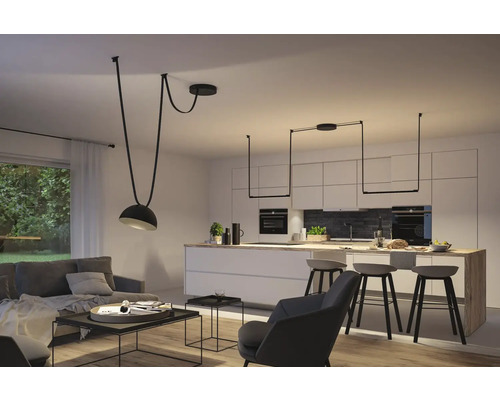 Helles Wohnzimmer mit Pendelleuchten über Sofa und Kücheninsel.