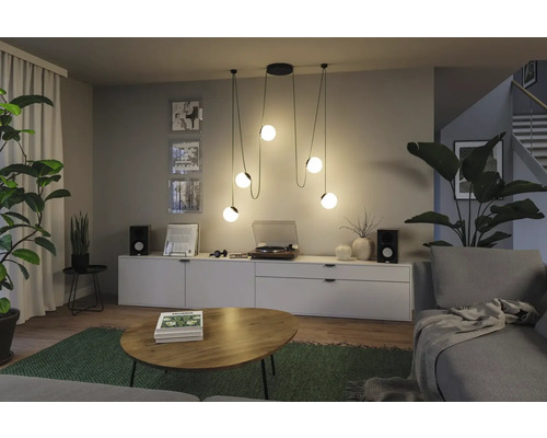 Wohnzimmer mit Pendelleuchte, Kommode, Schallplattenspieler und Zimmerpflanzen für eine gemütliche Atmosphäre.