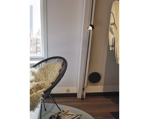 Einrichtung mit Sessel, Leselampe und Wohnaccessoires.