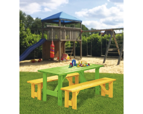 Kindersitzgruppe aus Holz mit Tisch und Bänken im Garten mit Spielplatz im Hintergrund