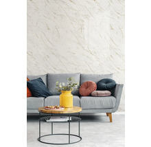 Graue Couch mit Zierkissen und Couchtisch vor einer Tapete mit Marmoroptik