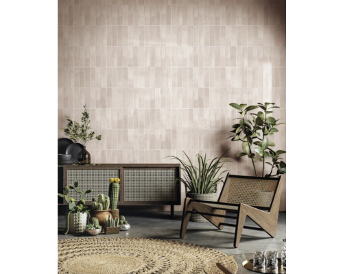 Wohnzimmer mit gefliester Wand, Kommode, Sessel und Pflanzen