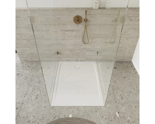 Badezimmer mit Duschwanne, Duscharmatur und Glastrennwand.