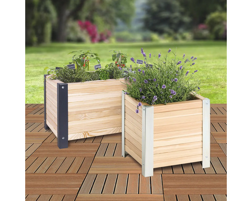 Zwei bepflanzte Holzkästen mit Metallecken auf einem Holzboden im Außenbereich.
