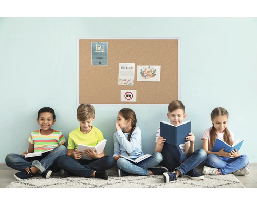 Fünf Kinder sitzen vor einer Korktafel und lesen Bücher.