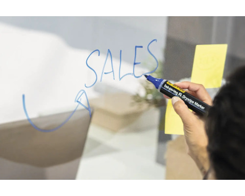 Eine Person schreibt mit einem abwischbaren Stift das Wort Umsätze auf eine transparente Oberfläche.