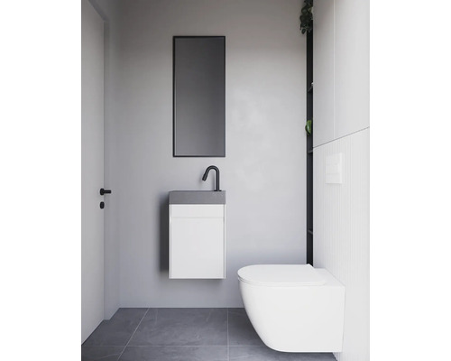 Modernes Badezimmer mit hängendem Waschtisch, Spiegel und Wandtoilette.