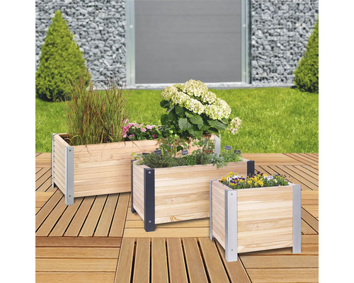 Drei Pflanzkästen aus Holz mit Pflanzen auf einer Holzterrasse.