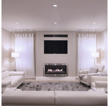 Wohnzimmer mit Kamin, Fernseher und weißen Möbeln für eine moderne Einrichtung