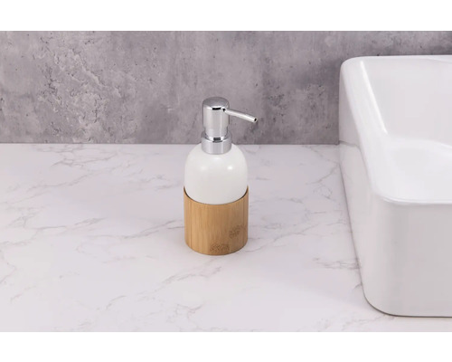 Seifenspender aus Keramik mit Bambusbasis und Chrompumpe neben Waschbecken