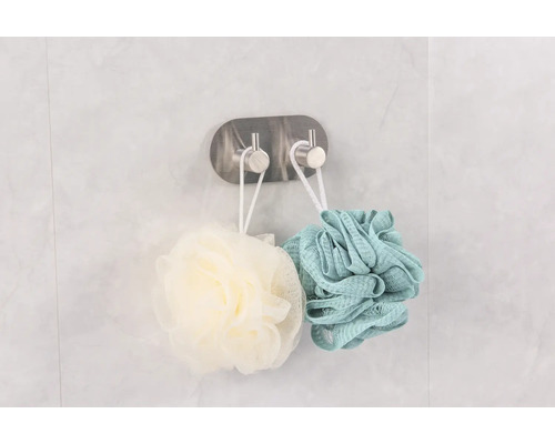 Zwei Duschschwämme hängen an einem Haken zur Badezimmeraufbewahrung.