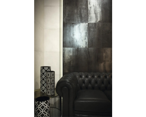 Szene mit dunklen Wandfliesen, schwarzem Ledersofa und dekorativen Vasen mit geometrischen Mustern