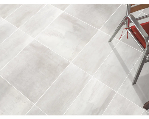 Heller Fliesenboden mit Stuhlbeinen im Bild