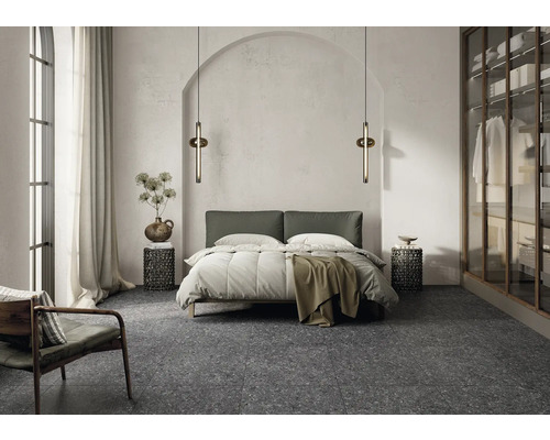 Schlafzimmer mit Bett, Nachttischen, Stehleuchten und einem Sessel auf einem Terrazzoboden.