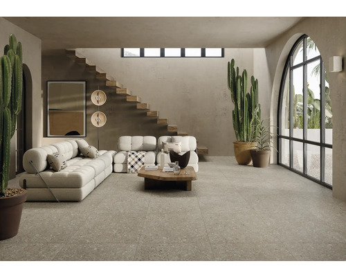 Wohnzimmer mit Sofa, Holztisch, Treppe und großen Fenstern