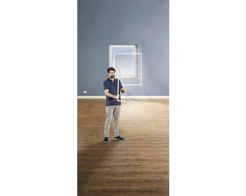 Ein Mann montiert einen Insektenschutzrahmen vor einem Fenster.