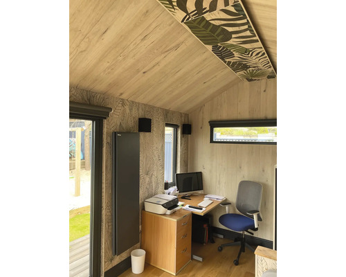 Büro mit Schreibtisch, Bürostuhl, Drucker, Heizkörper und floralen Akzenten