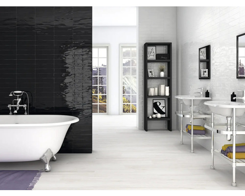 Badezimmer mit freistehender Badewanne, schwarzen und weißen Wandfliesen, Regal und Waschbecken