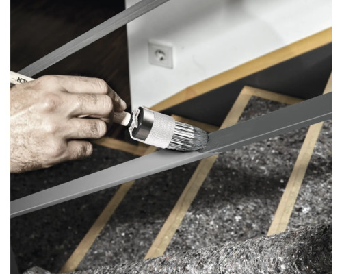 Anstreichen eines Geländers mit einem Pinsel.