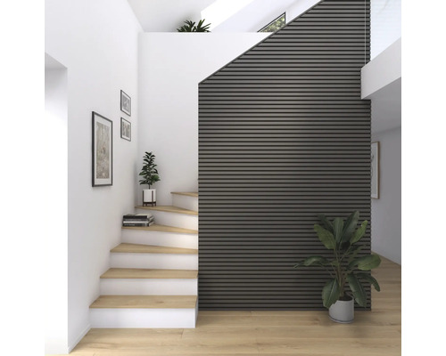 Heller Eingangsbereich mit Treppe, Holzfußboden und Akustikpaneelen an der Wand.