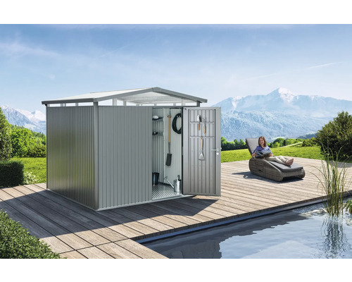 Gartenschrank aus Metall mit geöffneter Tür, Werkzeugen und einer Frau auf einer Sonnenliege neben einem Teich