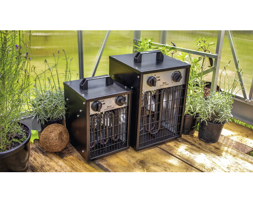 Zwei Gewächshausheizer mit einer Leistung von zwei Kilowatt und drei Kilowatt stehen auf einem Holzboden.