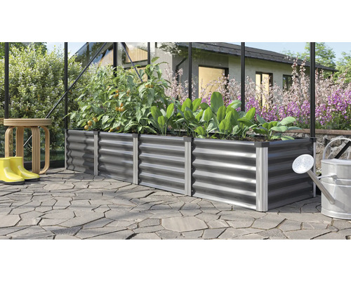 Hochbeet aus Metall mit Pflanzen, Gießkanne und Gummistiefeln
