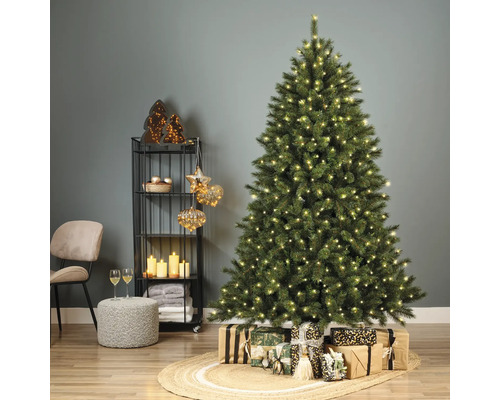 Dekorierter Weihnachtsbaum mit Geschenken, Regal mit Dekorationen und Sitzgelegenheit in einem Wohnzimmer