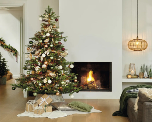 Weihnachtlich eingerichtetes Wohnzimmer mit geschmücktem Weihnachtsbaum, Kamin und Geschenken