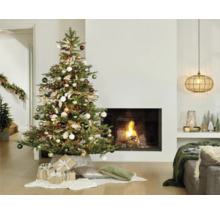 Weihnachtsbaum geschmückt mit Kugeln und Geschenken im Wohnzimmer mit Kamin.