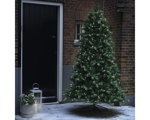 Künstlicher Weihnachtsbaum mit Lichtern vor einem Haus