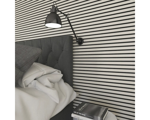 Schlafzimmer mit Bett, Nachttischlampe und gestreifter Wand