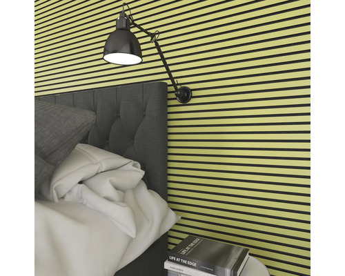 Schlafzimmer mit Akustikpaneelen an der Wand, Bett und Lampe