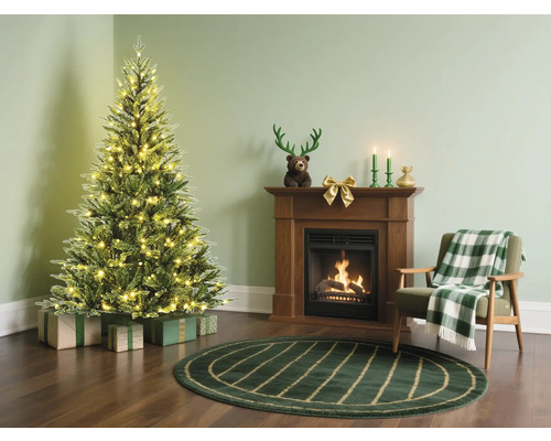 Weihnachtsszene mit Tannenbaum, Kamin und Sessel in einem gemütlichen Wohnzimmer