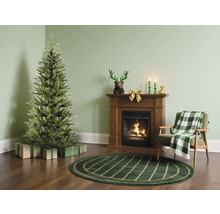 Wohnzimmer mit Weihnachtsbaum, Geschenken, Kamin und Sessel