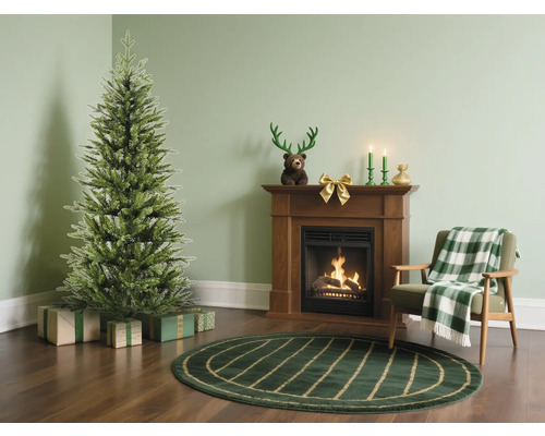 Wohnzimmer mit Weihnachtsbaum, Geschenken, Kamin und Sessel