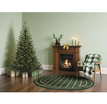 Weihnachtszene mit Weihnachtsbaum, Kamin und Sessel in einem Wohnzimmer