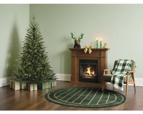 Weihnachtszene mit Weihnachtsbaum, Kamin und Sessel in einem Wohnzimmer