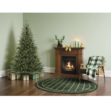 Wohnzimmer mit Weihnachtsbaum, Kamin und Sessel für festliche Atmosphäre