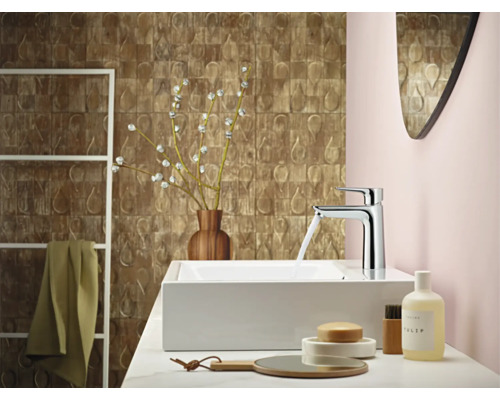 Modernes Badezimmer mit Waschtisch, Armatur, Spiegel und dekorativen Elementen für ein stilvolles Ambiente.