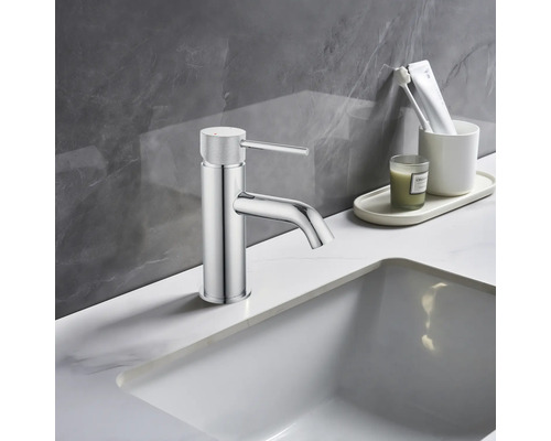 Waschtischarmatur im Badezimmer mit Waschbecken und Accessoires