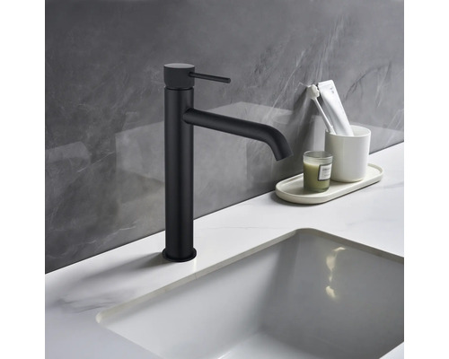 Schwarze Waschtischarmatur neben Waschbecken und Badutensilien auf Waschtisch