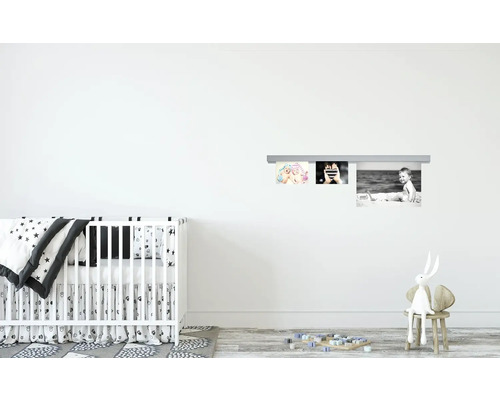 Babyzimmer mit Kinderbett, Spielzeug und Bilderleiste zur Wandmontage