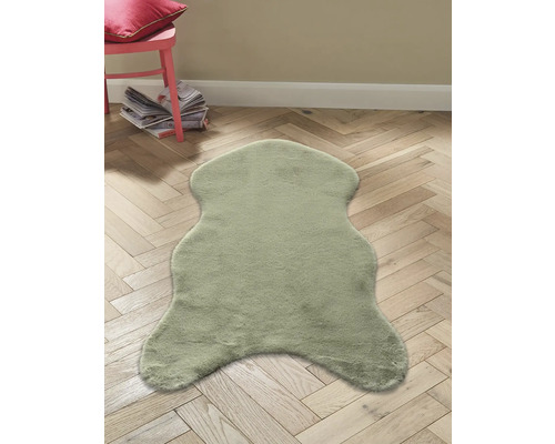 Dekofell auf Holzboden mit Stuhl und Zeitschriften im Hintergrund