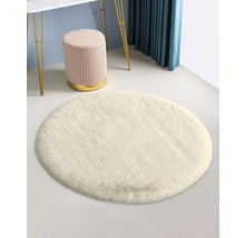 Weißer runder Teppich mit Hocker und Tisch im Hintergrund