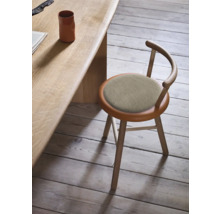 Holzstuhl mit gepolsterter Sitzfläche an einem Holztisch