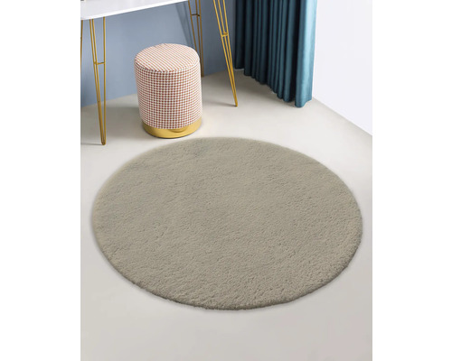 Runder Teppich neben Hocker und Tisch