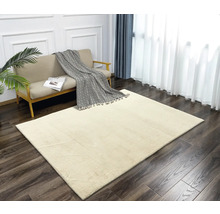 Beige Teppich in einem hellen Wohnzimmer mit Sofa und Vorhängen