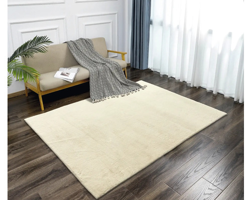 Beige Teppich in einem hellen Wohnzimmer mit Sofa und Vorhängen