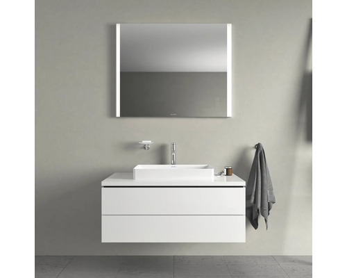 Badezimmer mit Waschbecken, Unterschrank und beleuchtetem Spiegel